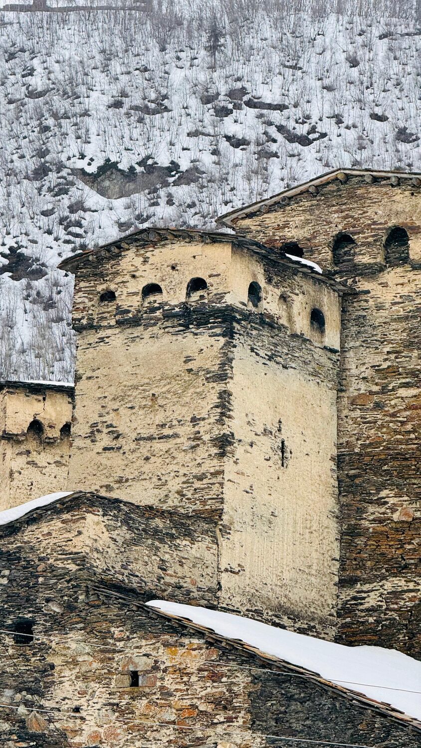 Stone tower below snowy peaks